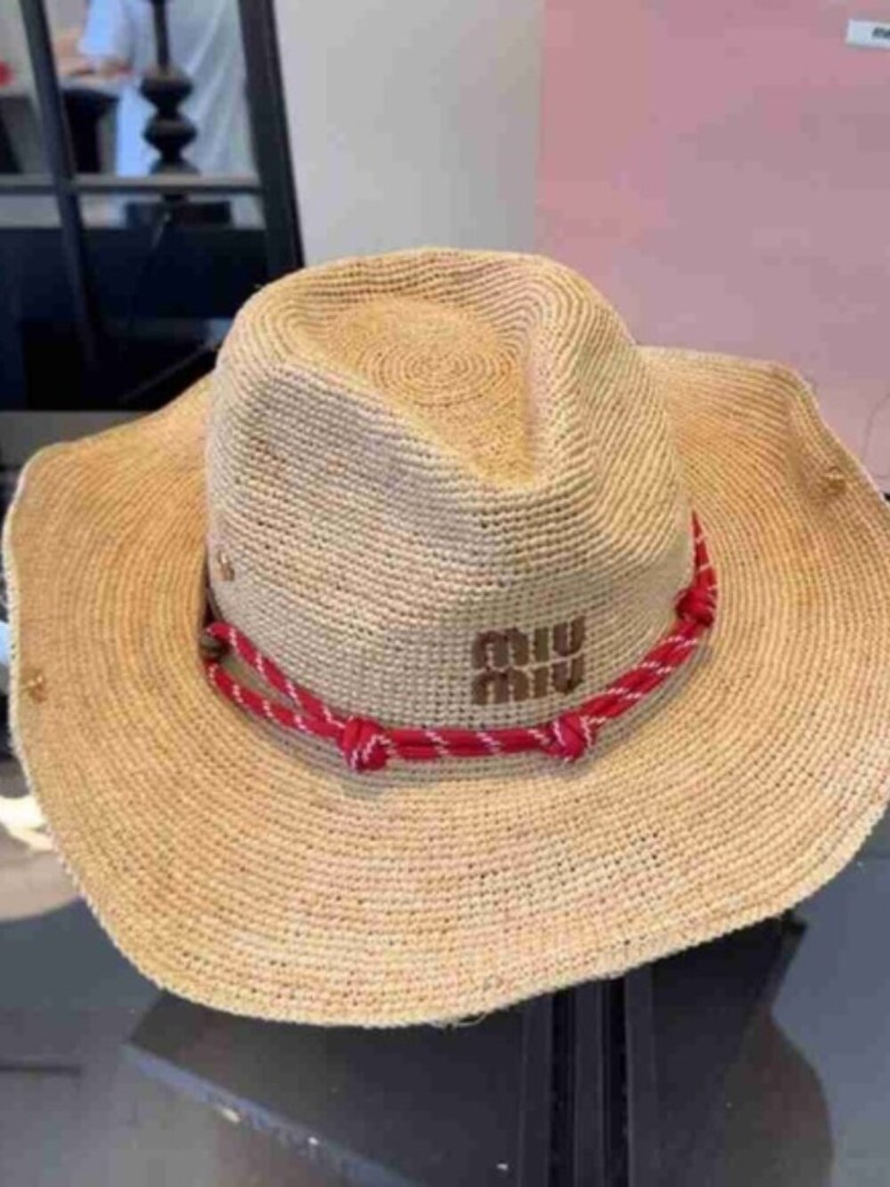 Miu Miu natural straw hat featuring a charming red braided trim.